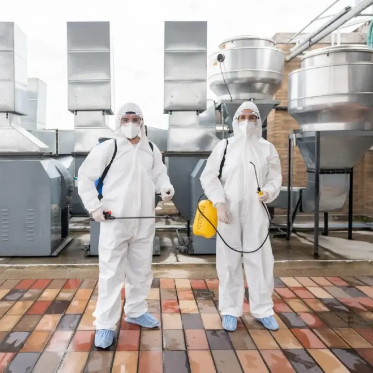 Two professional holding an AC sanitizer